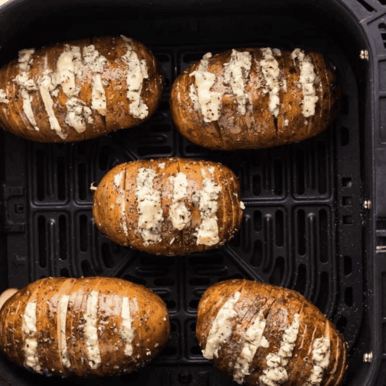 Air frying Hasselback potatoes, brushing with butter, then topping with creamy bleu cheese and chopped chives.