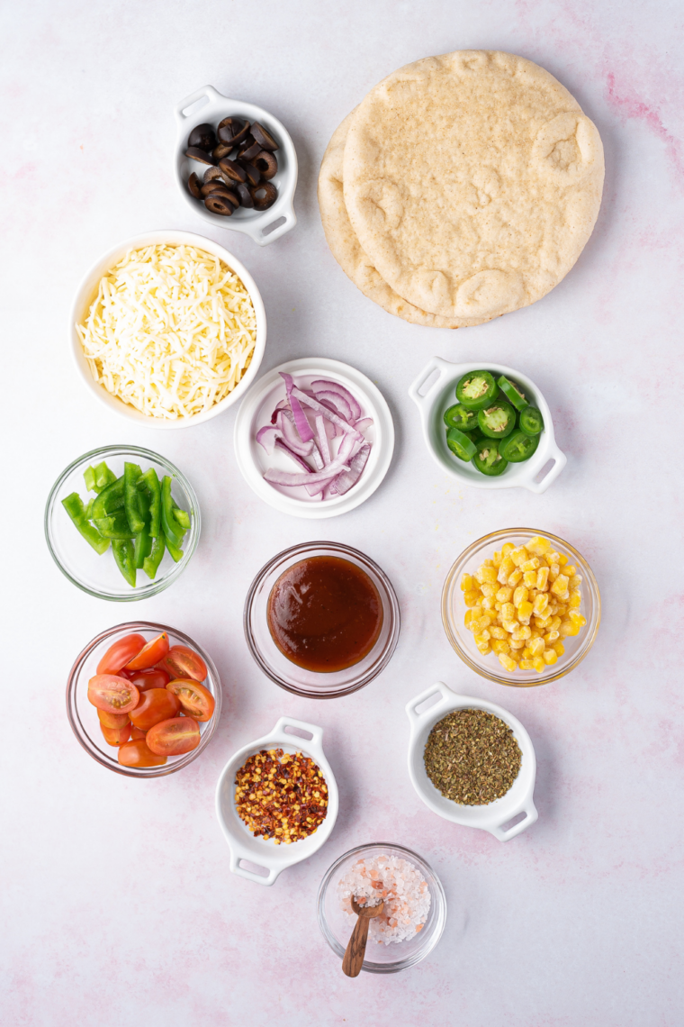 Ingredients for air fryer pita pizza: pita bread, pizza sauce, shredded mozzarella, and Italian seasoning
