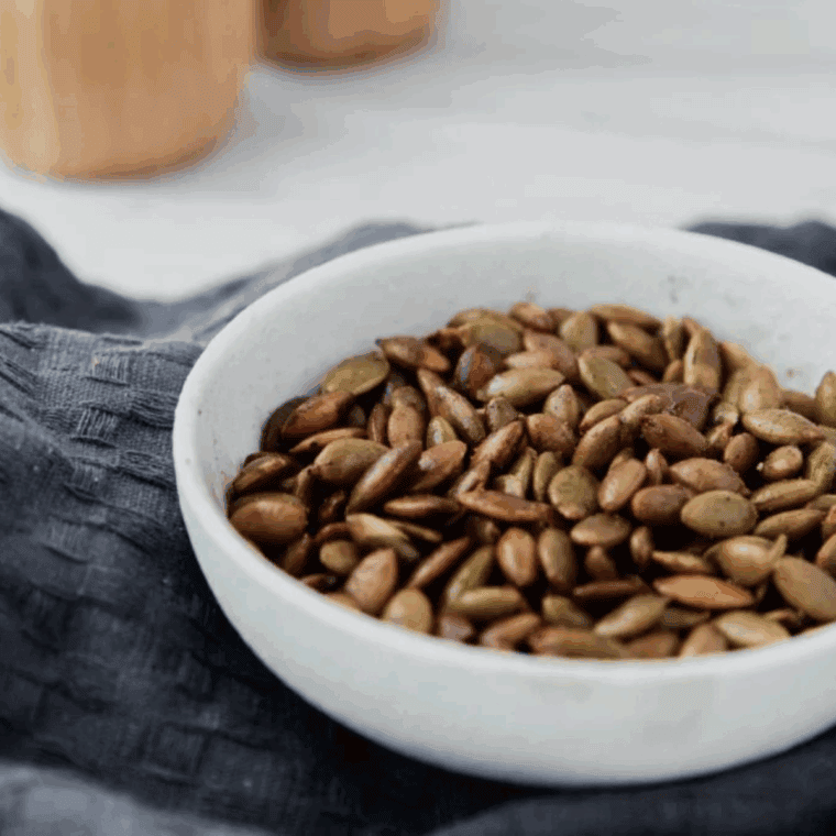 Golden roasted pepitas in the air fryer basket, seasoned and ready to enjoy.