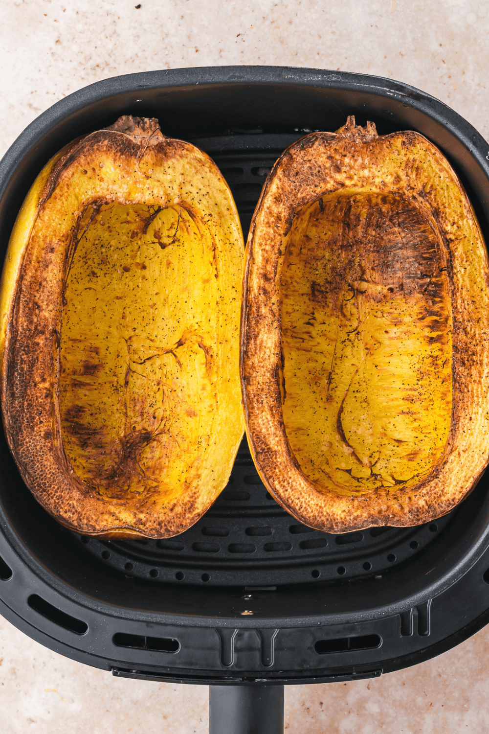 Paring knife sliding into the flesh of cooked spaghetti squash to test doneness
