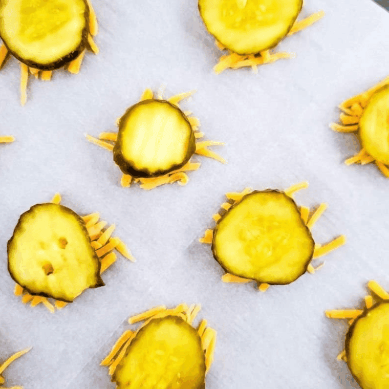 Place the cheese in the air fryer basket on parchment paper, and then add some shredded cheese.