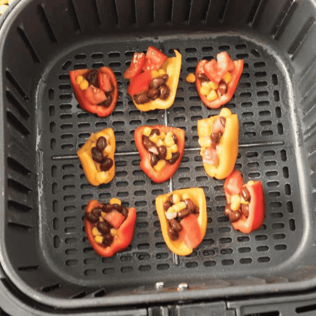 Filled peppers placed in the air fryer at 370°F, cooking until cheese melts.