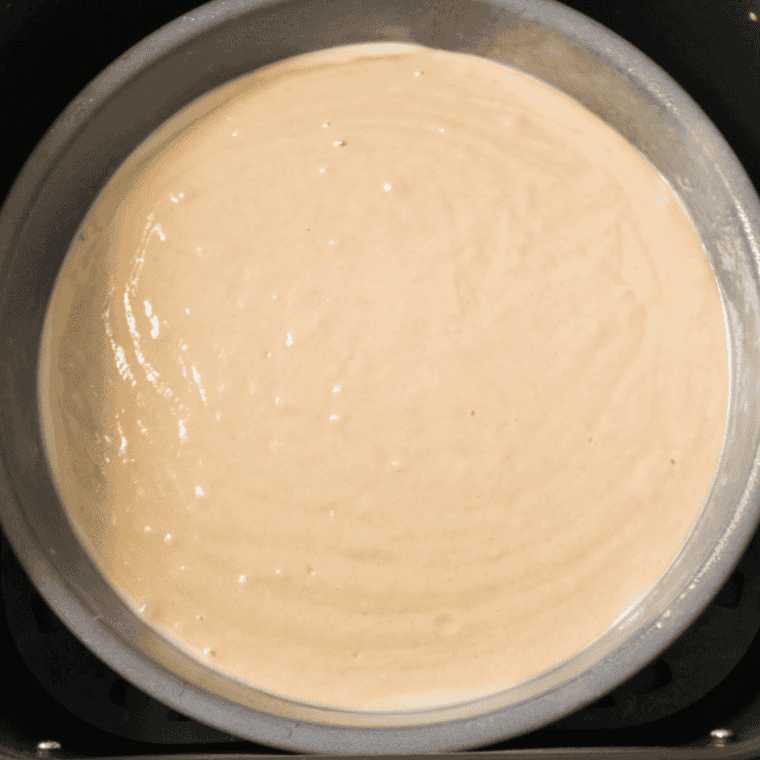 Cake batter poured evenly over pineapple slices in Instant Pot pan.