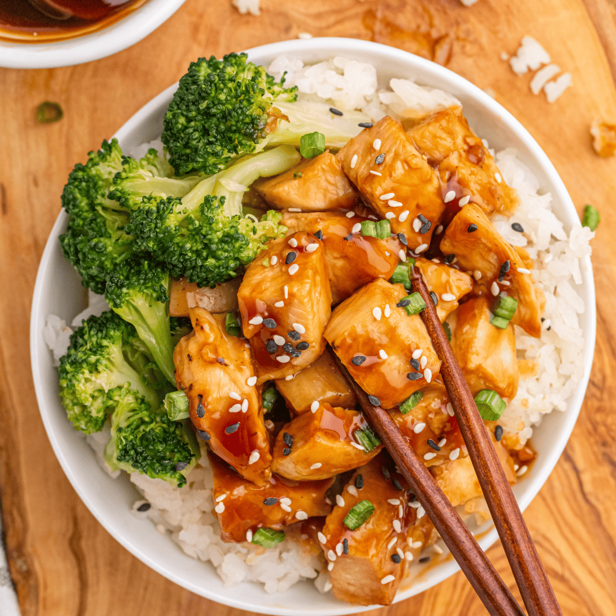 "Homemade Halal Guys chicken and rice with marinated grilled chicken, yellow turmeric rice, lettuce, tomatoes, and white sauce on a platter."
