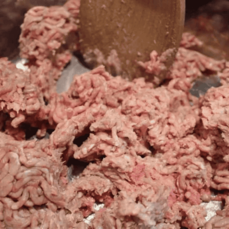 Ground beef and diced yellow onion browning together in Instant Pot inner pot on saut&eacute; setting