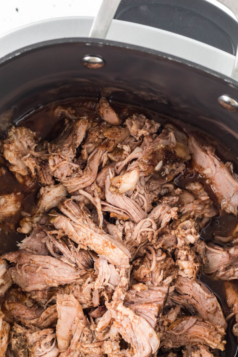 : Shredding slow cooker chicken with two forks for copycat Mission BBQ pulled chicken