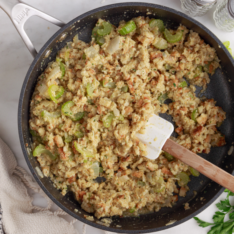 Chicken stuffing casserole garnished with fresh parsley, with one serving scooped out onto a plate