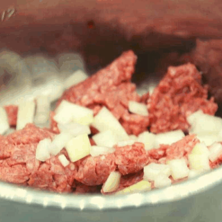Browning ground beef and diced onions in the Instant Pot using sauté mode until fully cooked."