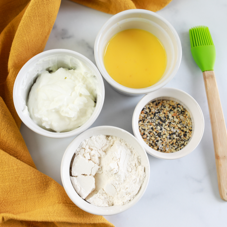 Mixing self-rising flour and Greek yogurt in a glass bowl to make easy no-yeast bagel dough
