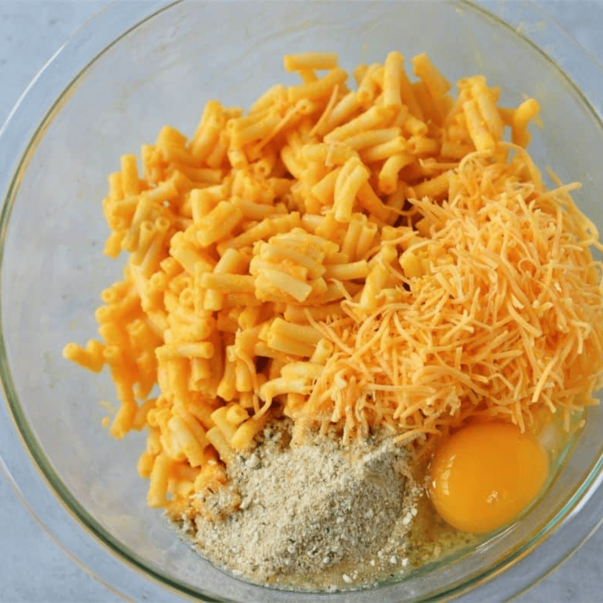 mixing macaroni and cheese ingredients together in a large bowl
