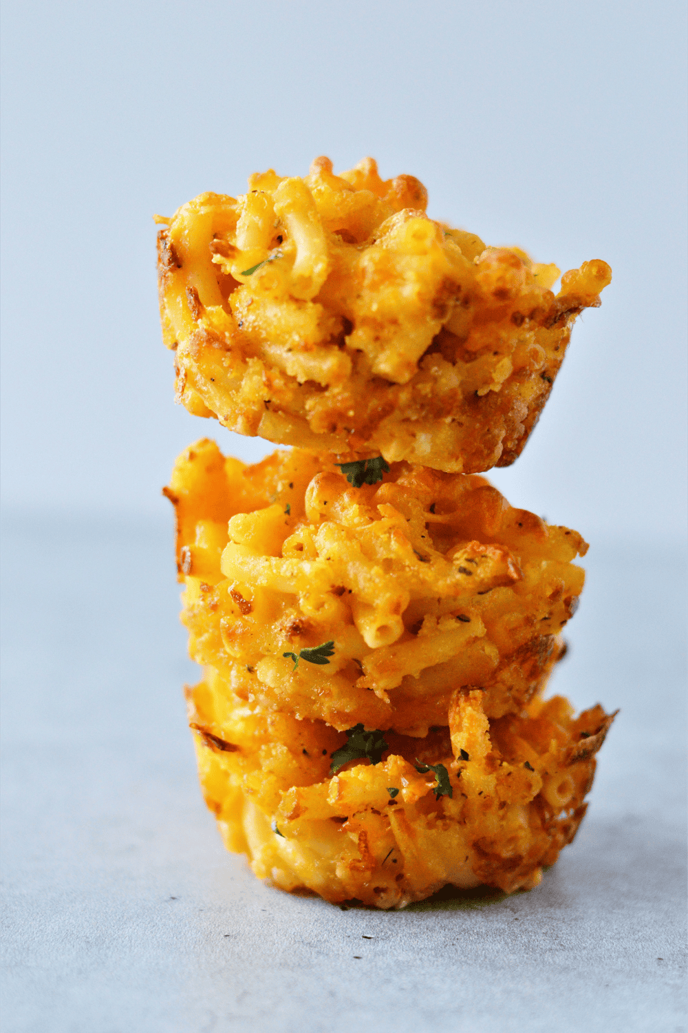 Golden, cheesy Air Fryer Macaroni and Cheese Muffins in a muffin tin, crispy on the edges and soft inside.