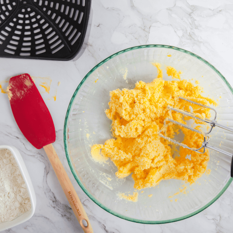 Large bowl with flour, butter, and sugar mixed into smooth cookie dough.