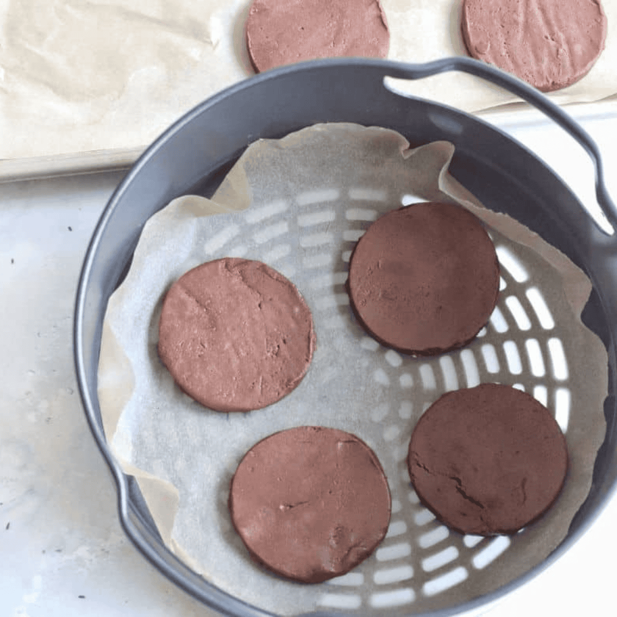 Shaping brownie cookie dough into balls on parchment paper.