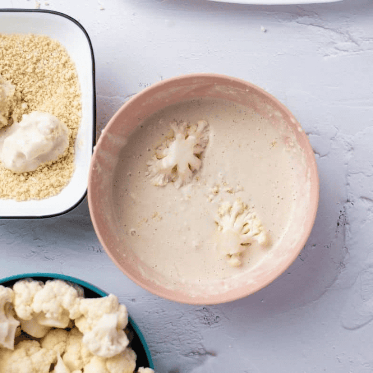 Mixing flour, cornstarch, and spices with milk to create smooth cauliflower wing batter.