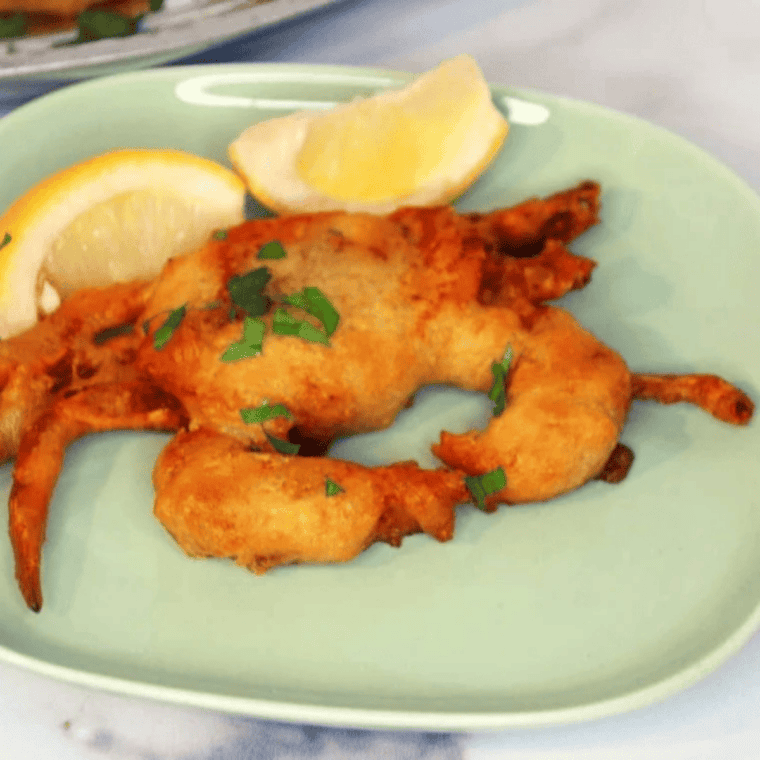 Air fryer crispy soft shell crab on a plate with lemon wedges