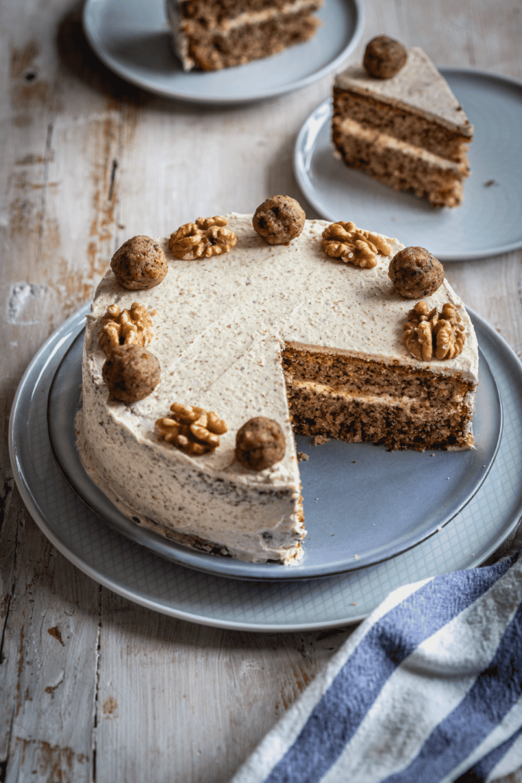 Golden brown air fryer walnut cake, frosted and garnished with chopped walnuts, ready to serve.