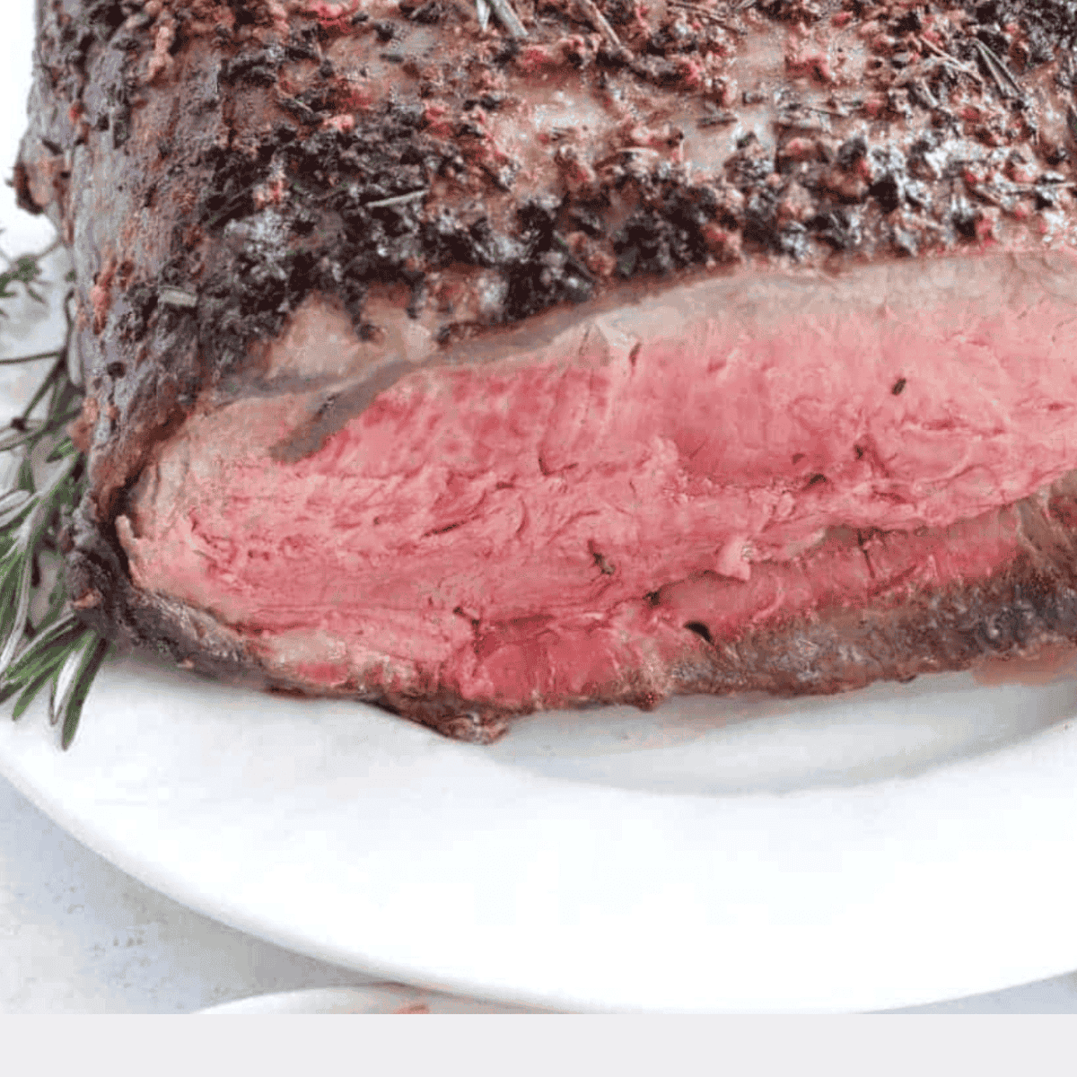 Perfectly cooked air fryer prime rib with crispy exterior and juicy interior, served with sides."
