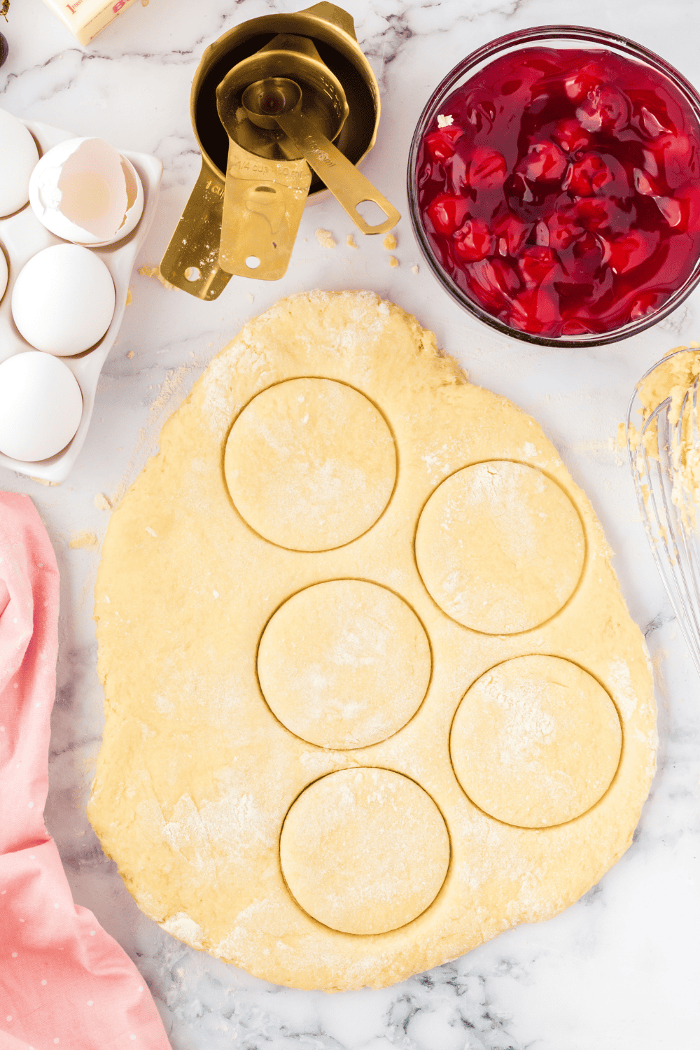 Rolling air fryer donut dough into ½-inch thick sheet and cutting 4-inch circles.