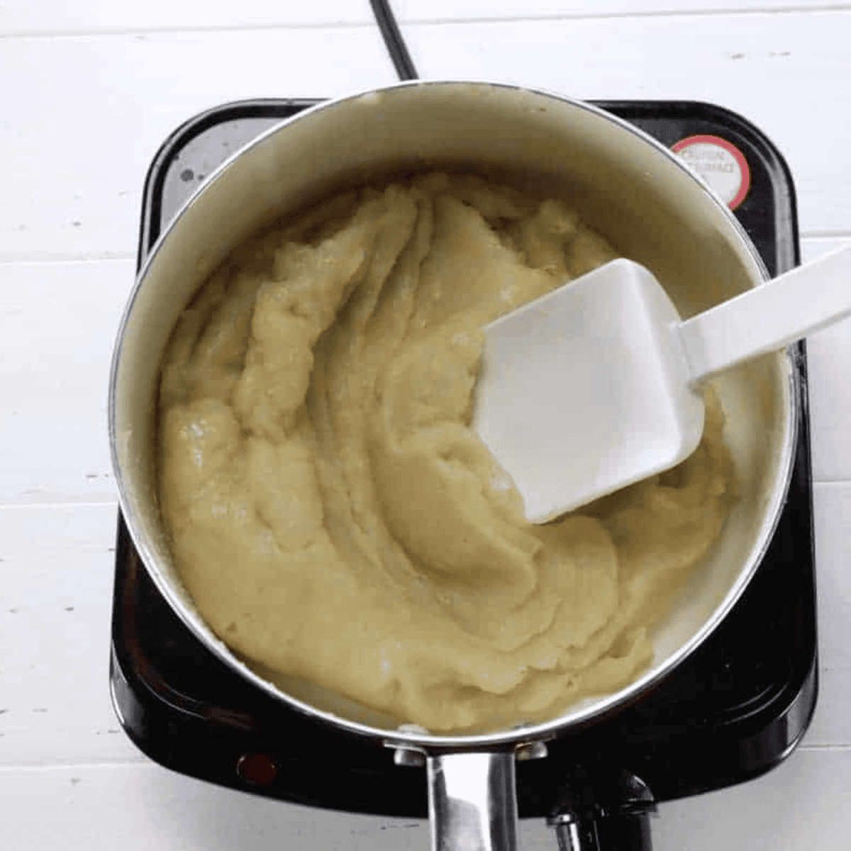 Cooked choux dough resting in a glass mixing bowl before adding eggs for air fryer churros