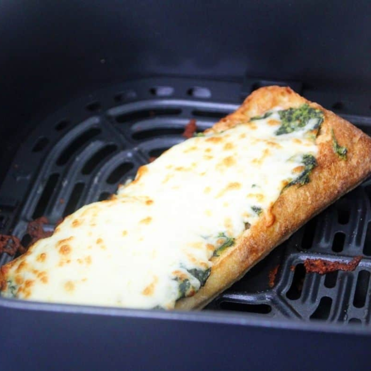Air fryer Spinach Florentine pizza with melted mozzarella and creamed spinach on toasted baguette.