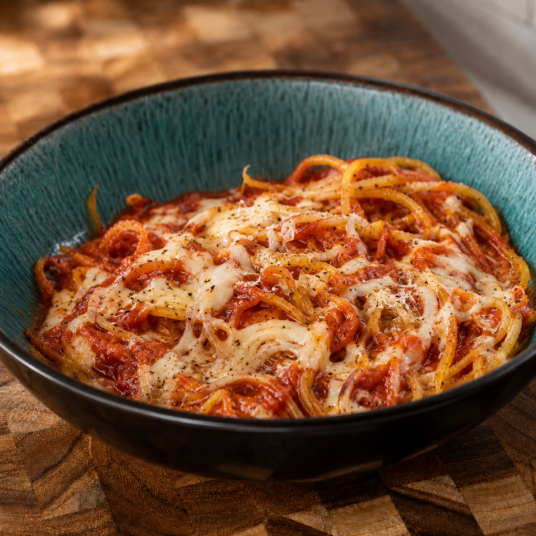 Air fryer butternut squash noodles topped with marinara sauce in a white bowl