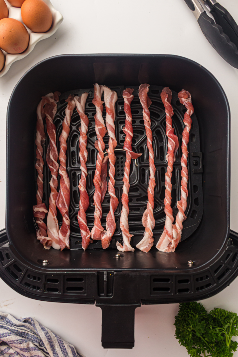 Raw Twisted Bacon in the air fryer basket.