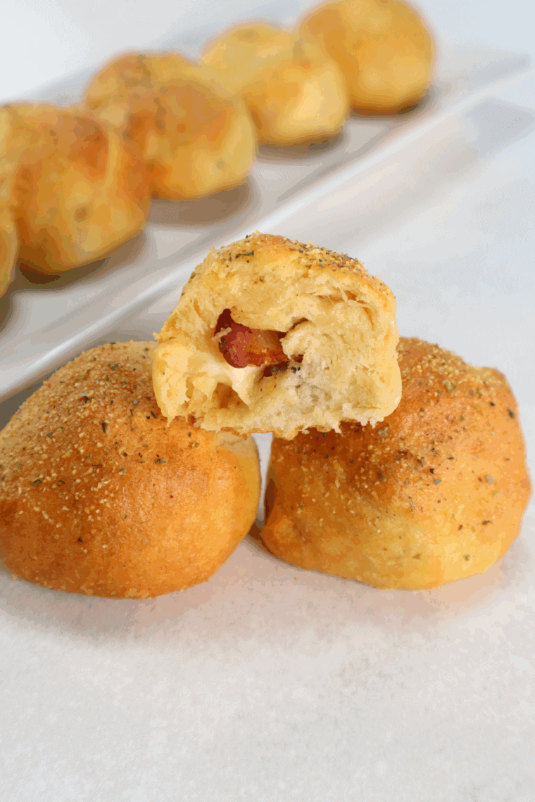 Air fryer bacon-wrapped cheese bombs with melted mozzarella inside, golden and crispy