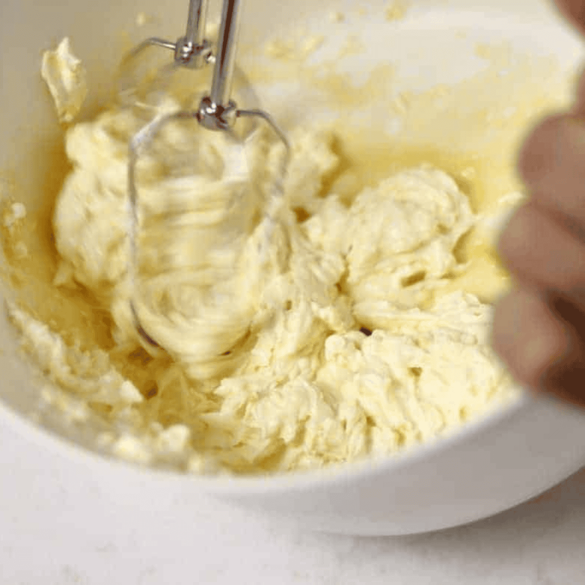 Whisking eggs, sugar, flour, lemon zest, lemon juice, milk, and salt in a bowl to prepare lemon filling for air fryer lemon bars.