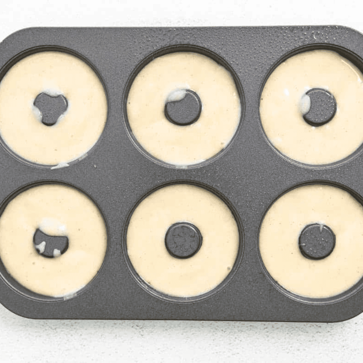 Piping donut batter into donut pan before air frying at 320 degrees