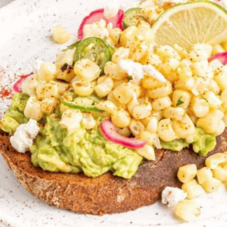air fryer elote avocado toast topped with corn, cotija cheese, lime, and cilantro