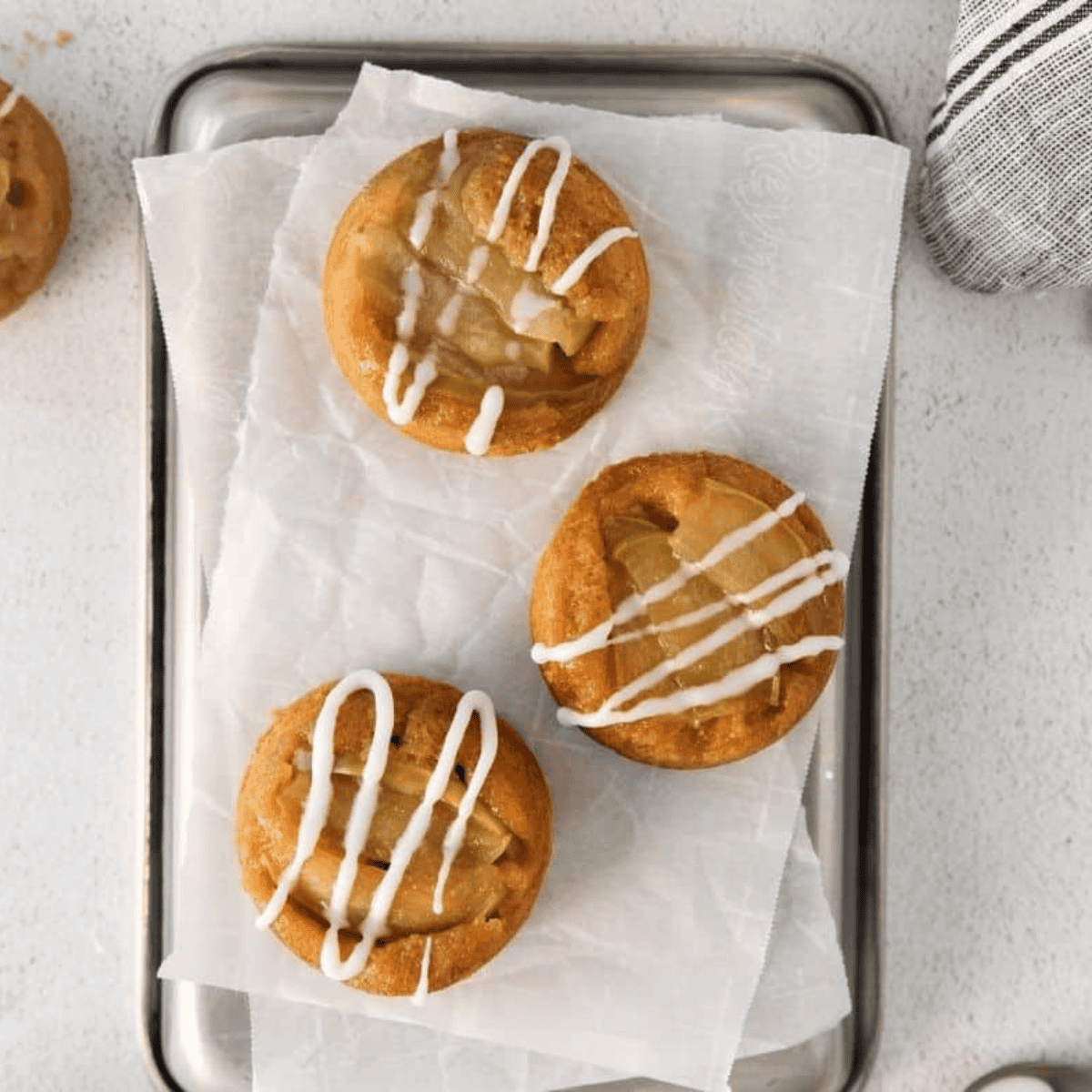 Mini Easy Amish Apple Cakes with golden caramelized apple slices on top, served on a rustic plate.