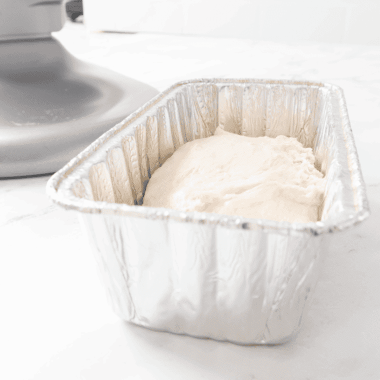 dough kneaded on floured surface, covered in greased bowl, rising until doubled