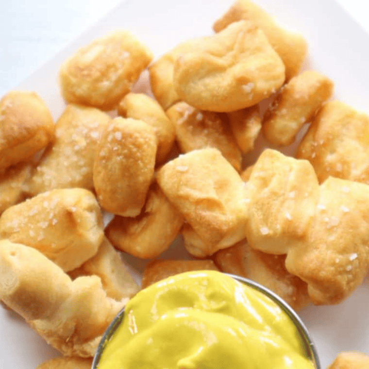 Serve — Golden air fryer bite-size pretzels plated and served warm with dip