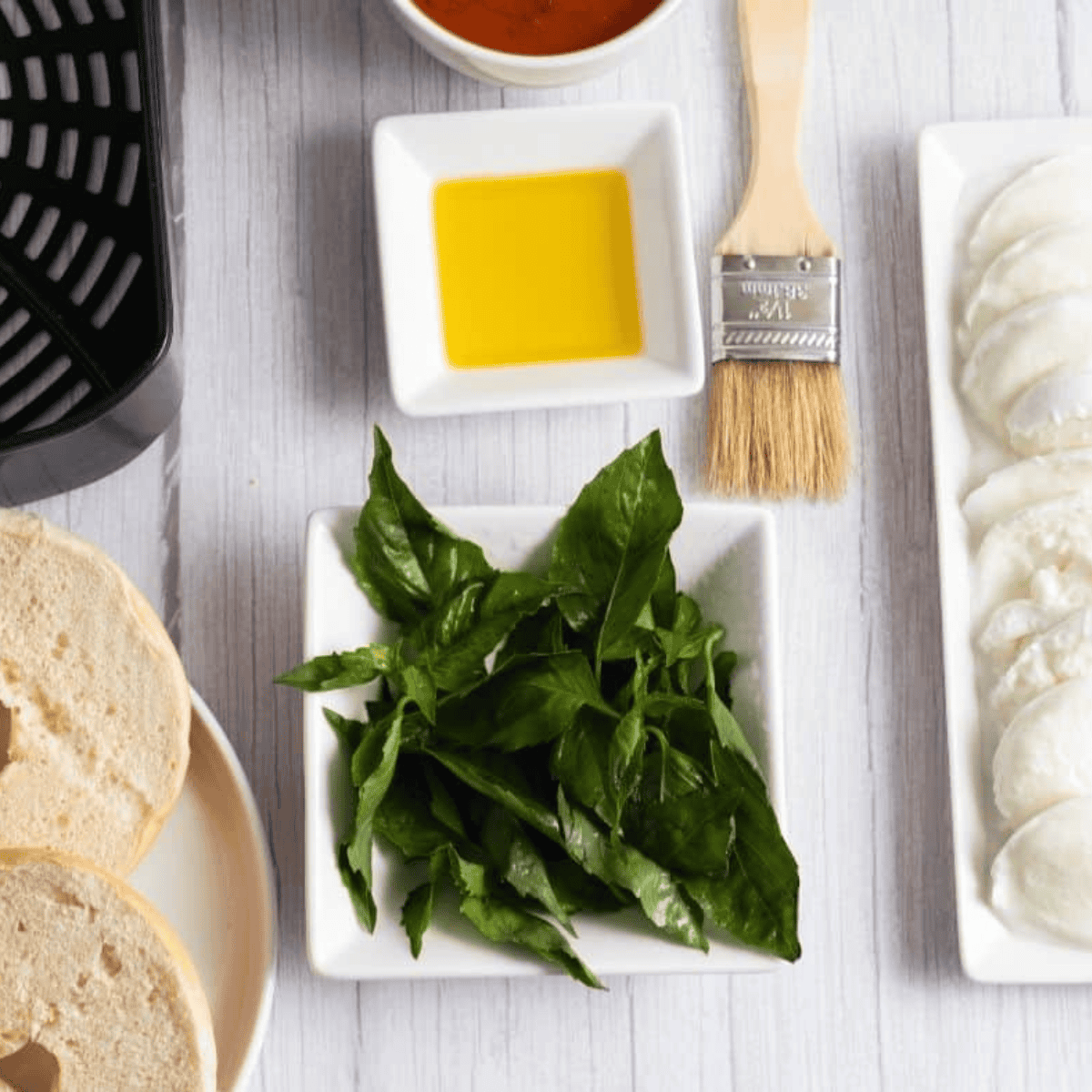 Ingredients needed for Air Fryer Margherita Pizza Bagels on kitchen table.