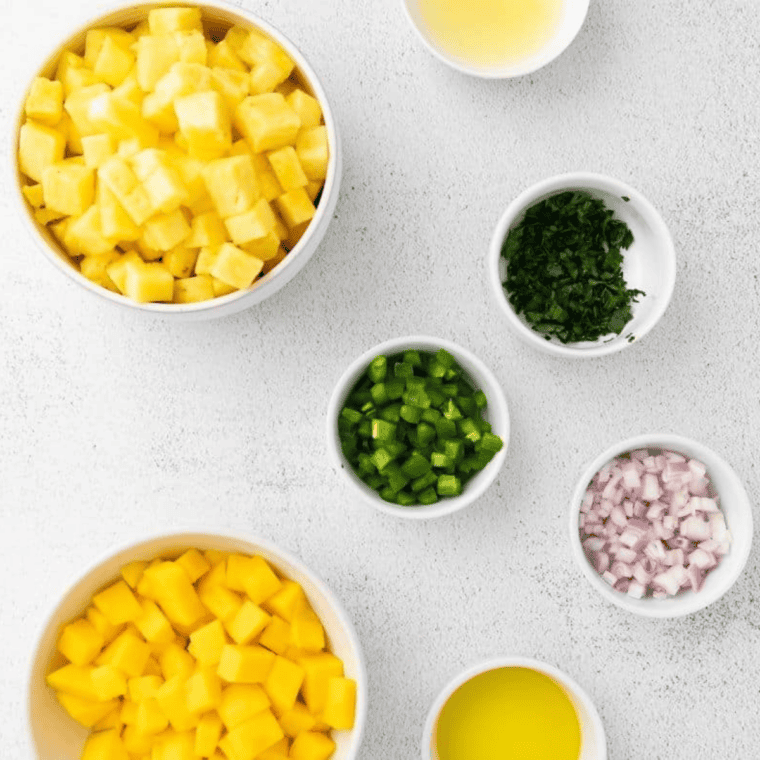 Ingredients needed for Easy Baja Fresh Copycat Pineapple Salsa Recipe on kitchen table.