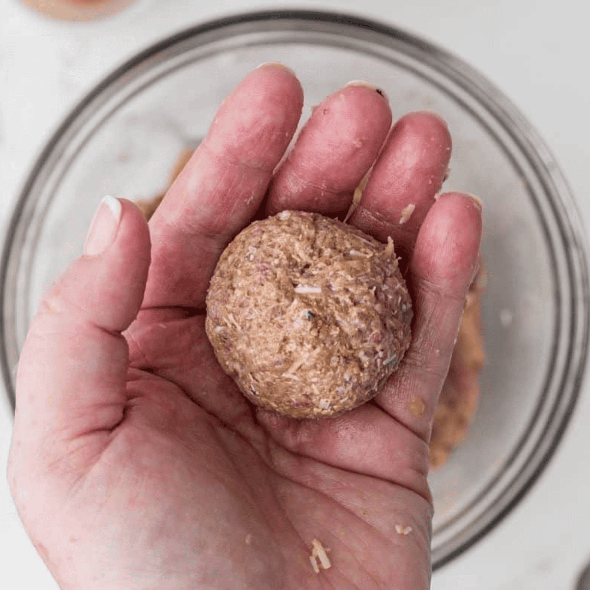 Forming evenly sized turkey meatballs, about 1 to 1.5 inches in diameter, on a cutting board.