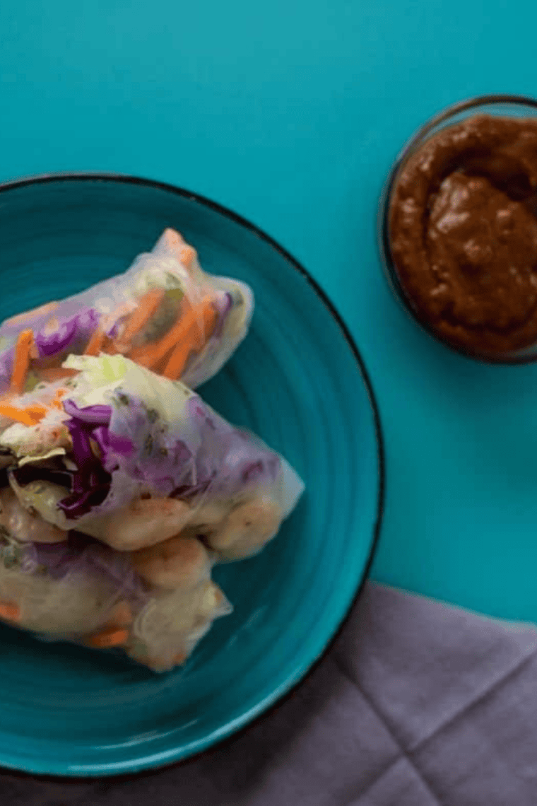 Chilled shrimp and vegetable spring rolls served with a small bowl of peanut dipping sauce.