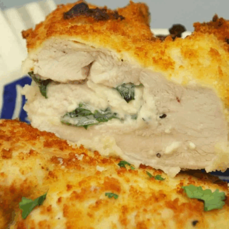 Air fryer feta and spinach stuffed chicken breasts sliced to show creamy filling.