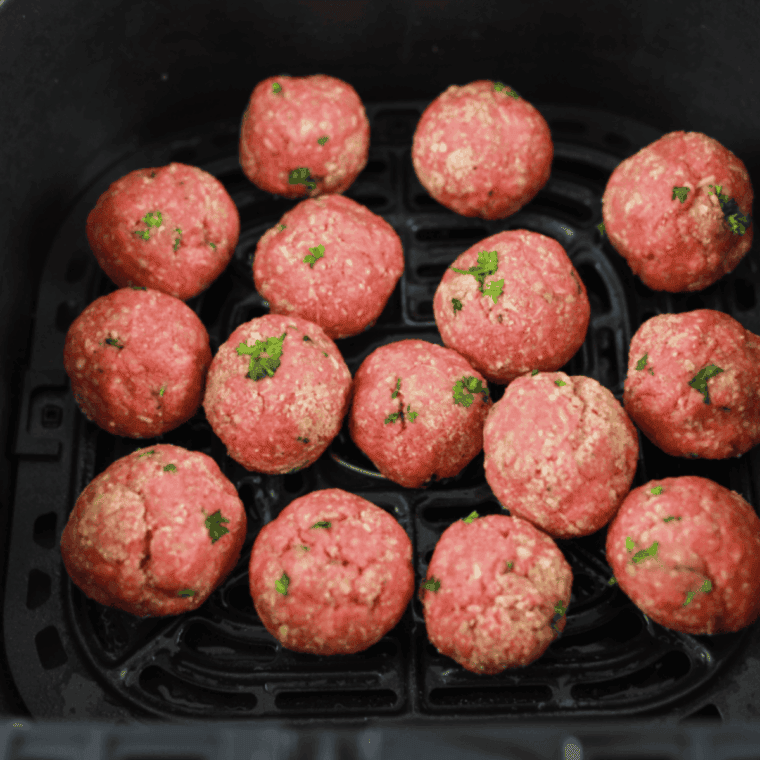 Placing meatballs in the air fryer basket, setting temperature to 350°F, and cooking for 8-10 minutes. Serving with marinara sauce or in a hoagie roll.