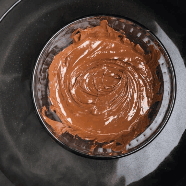 Melting chocolate in a glass bowl over simmering water using double boiler method