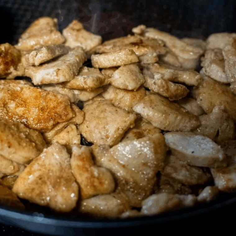 Assembled chicken fajita rice bowl with air-fried chicken, peppers, onions, pico de gallo, guacamole, black beans, and sour cream.