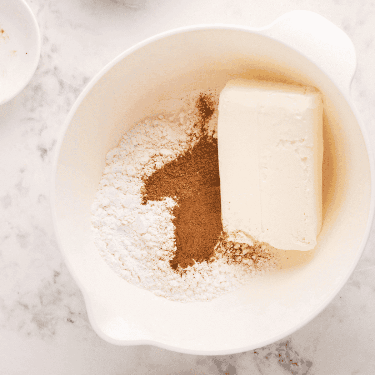 Cream cheese frosting being mixed and drizzled over air fryer cinnamon roll monkey bread
