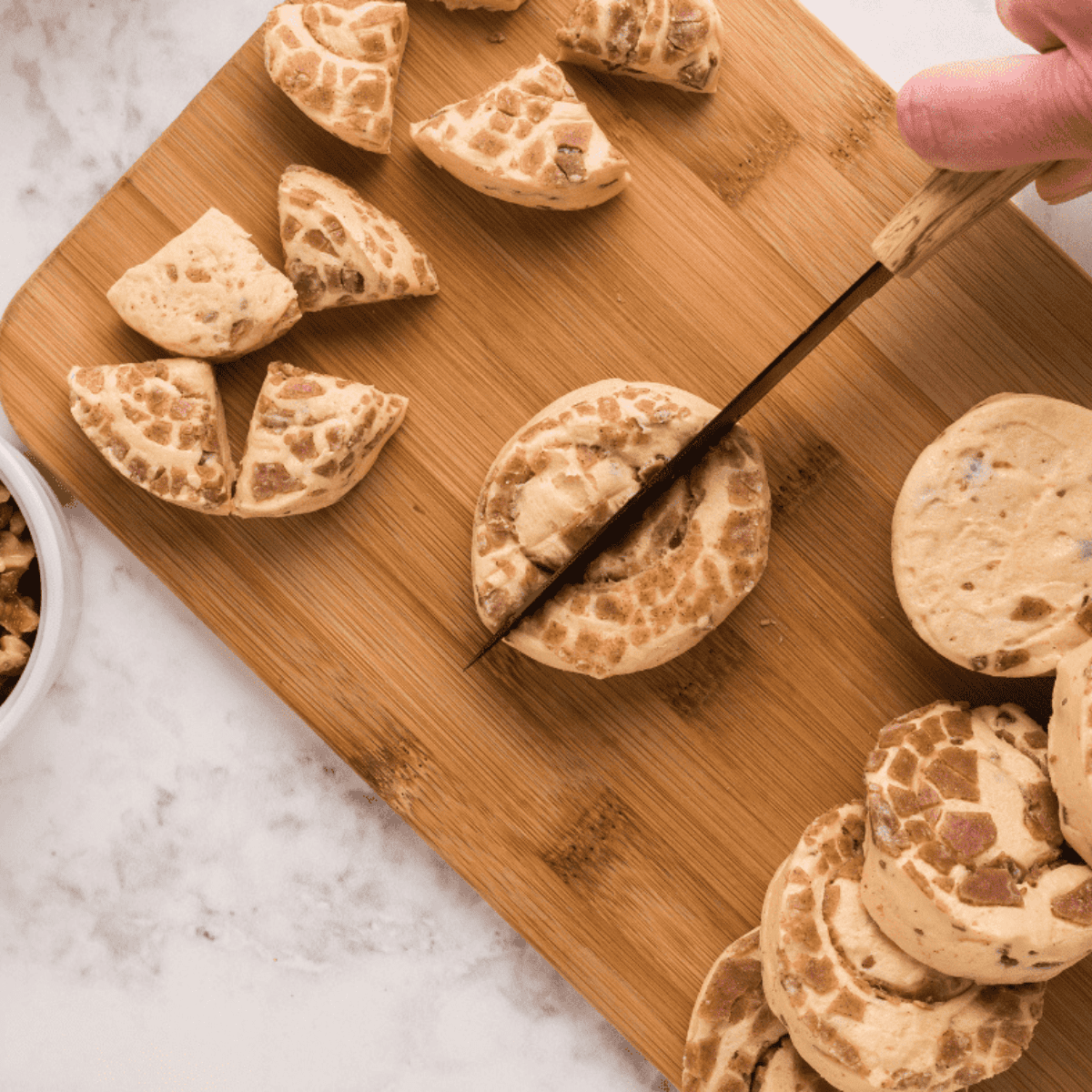 Sliced cinnamon rolls in a bowl while air fryer preheats to 375°F