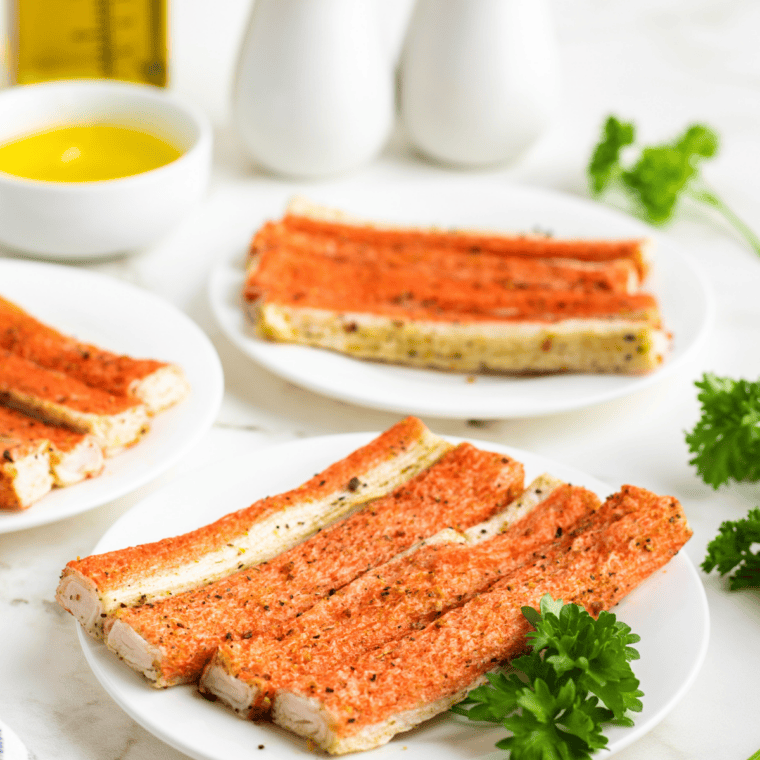 Crispy air fryer crab bites served with garlic butter dipping sauce on a white plate.