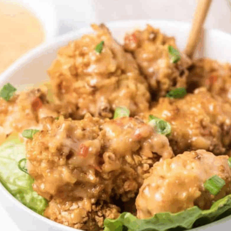 A small bowl of creamy homemade Bang Bang Sauce made with just three ingredients, perfect for dipping or drizzling over crispy shrimp.