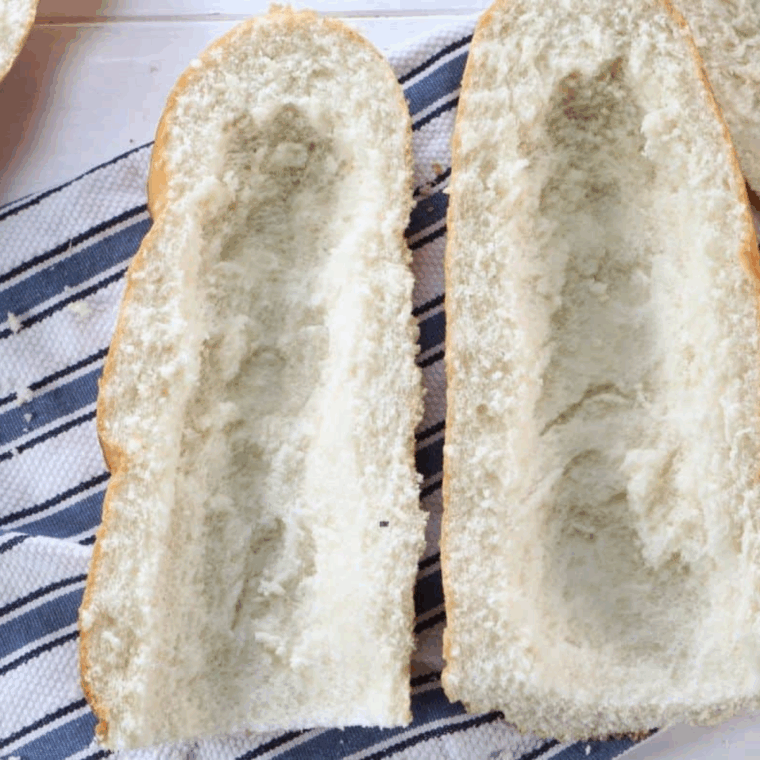 Loaf of bread cut in half with center scooped out for stuffing