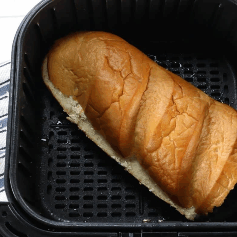 Air fryer stuffed bread cooking until cheese is melted