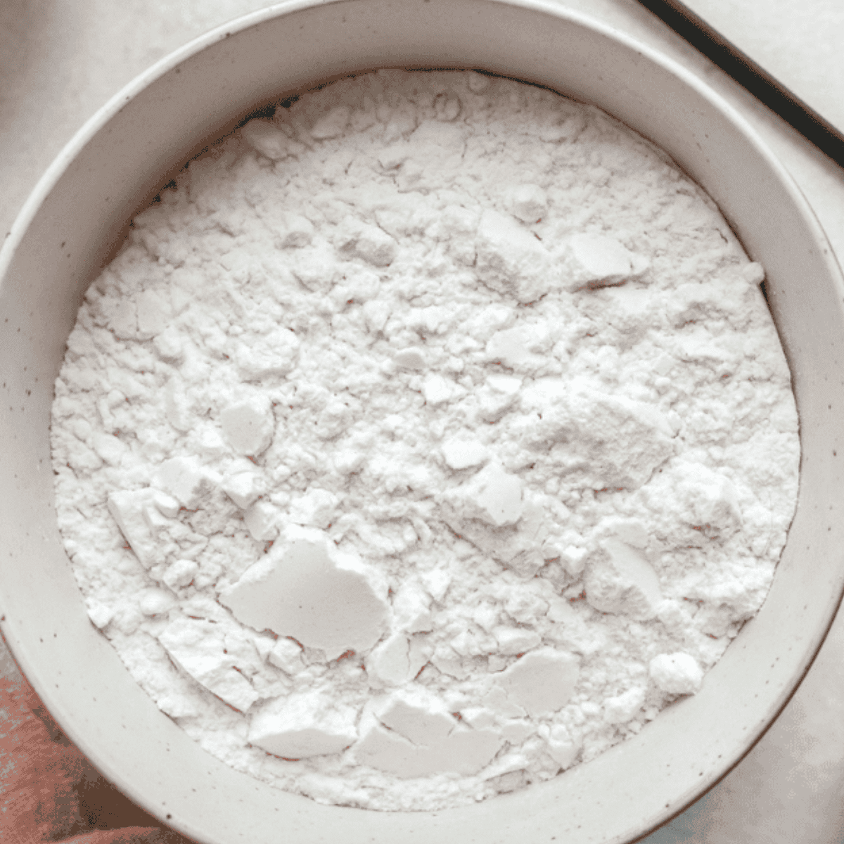 Whisking flour, baking powder, baking soda, cinnamon, salt, and allspice for peach muffins