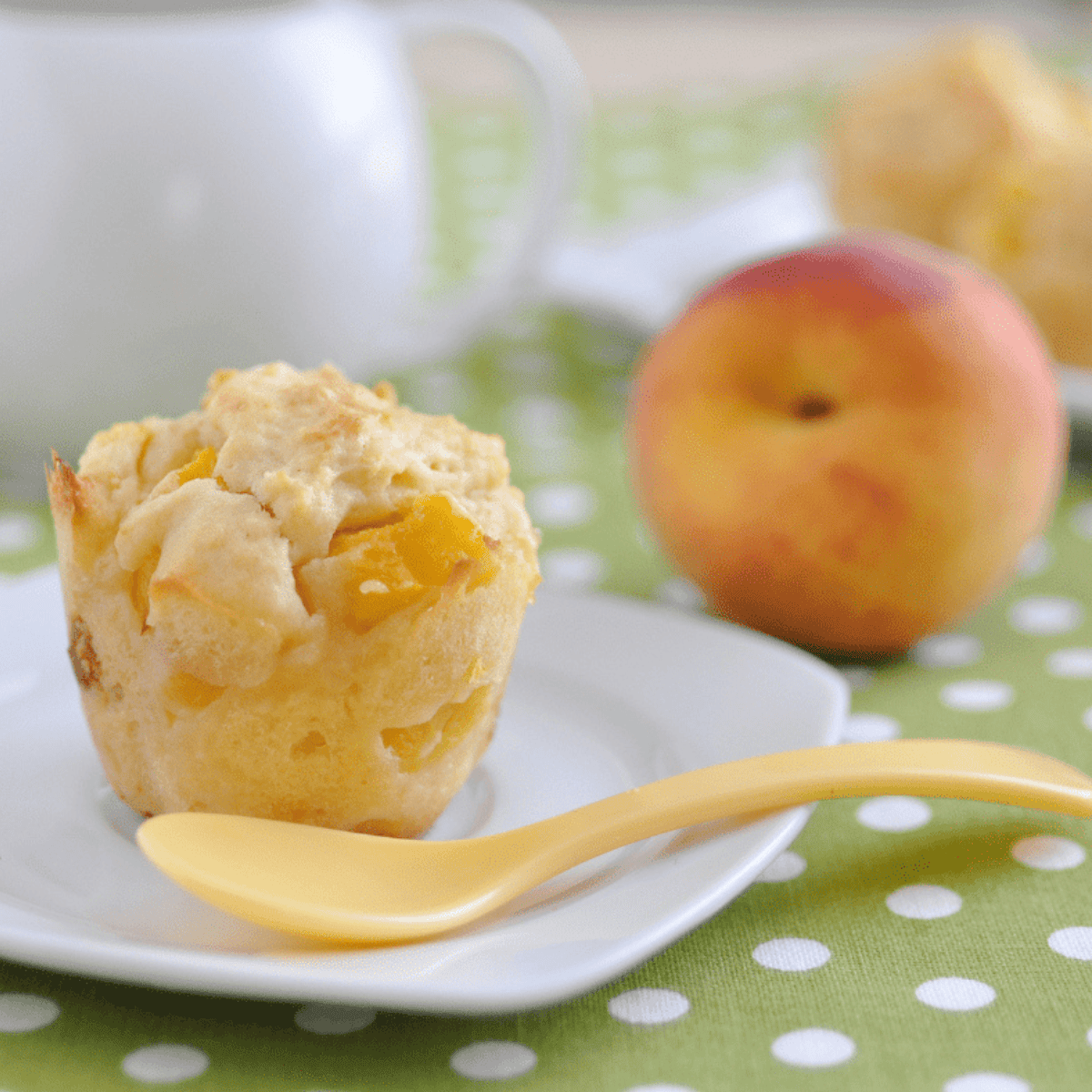 Golden air fryer peach muffins with soft, fluffy centers and juicy peach pieces, freshly baked and ready to enjoy.