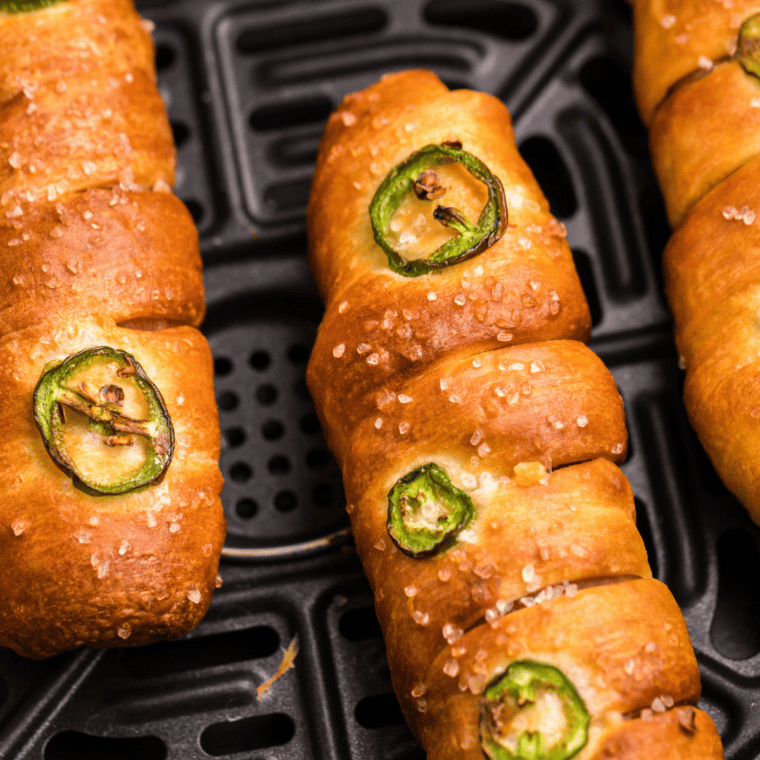 Dough-wrapped pretzel cheese dogs brushed with egg wash and sprinkled with coarse sea salt